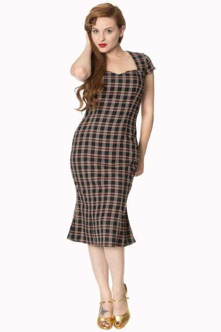 Model showcasing the Elvis Ain't Dead swing dress with a plaid check pattern and sweetheart neckline. Vintage-style rockabilly look.