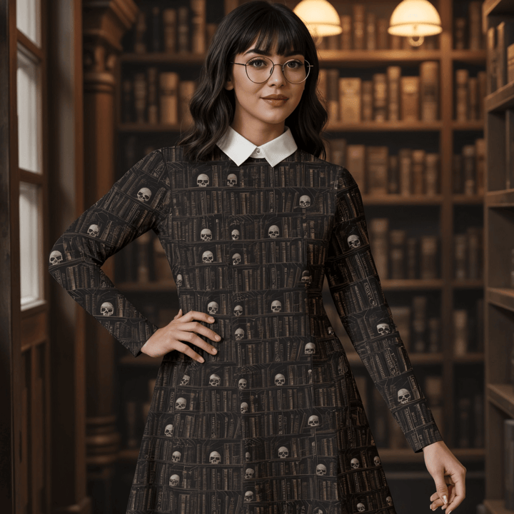 Model wearing The Haunted Library Vintage Goth Dress with skulls pattern, set against a backdrop of dark bookshelves.