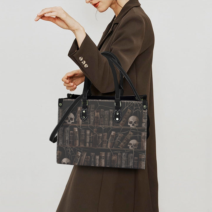 Vintage Haunted Library Handbag featuring skull and book design, carried stylishly by a woman in a dark brown coat.