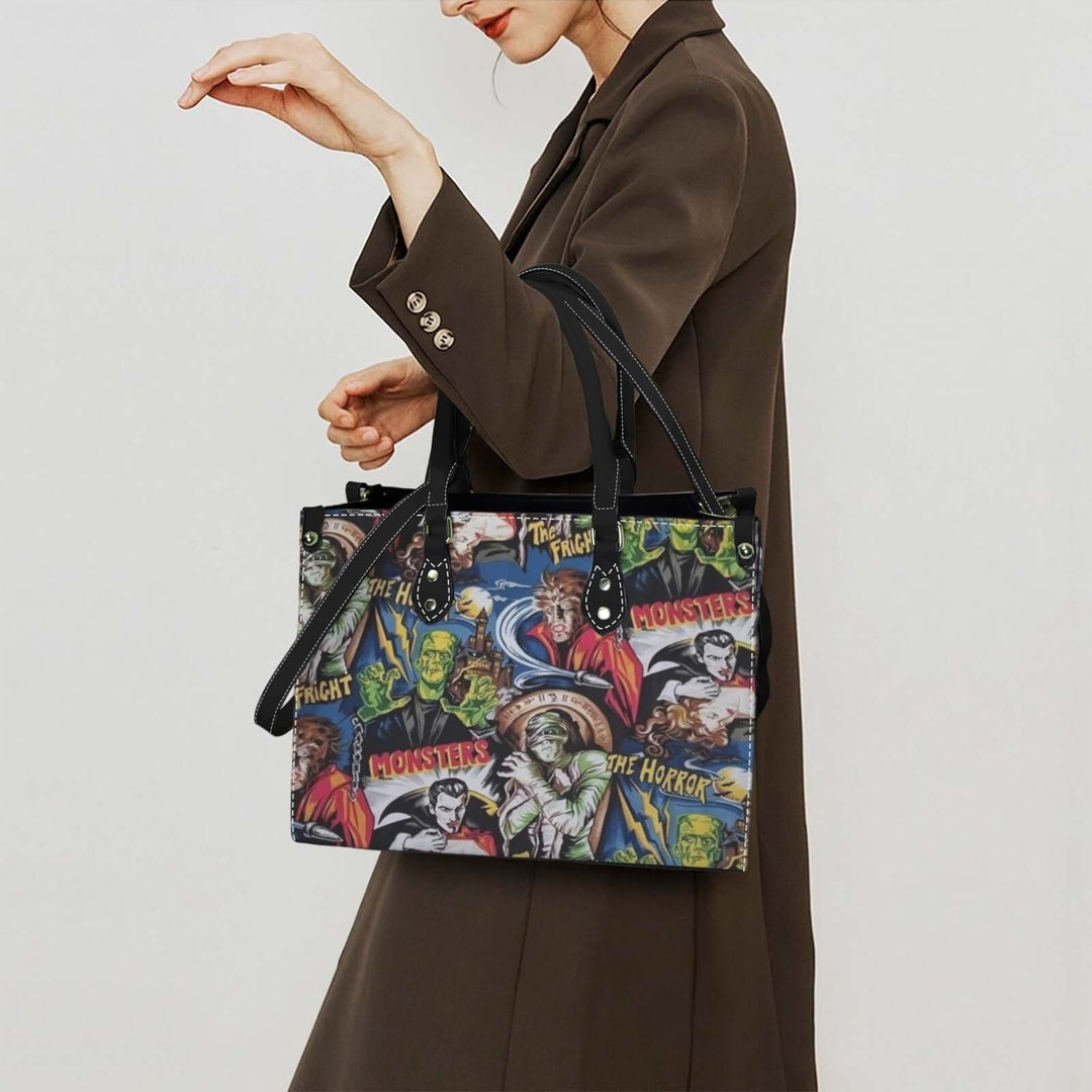 Woman carrying Hollywood Monsters Handbag featuring Dracula, Frankenstein, and Wolfman in a stylish outfit.