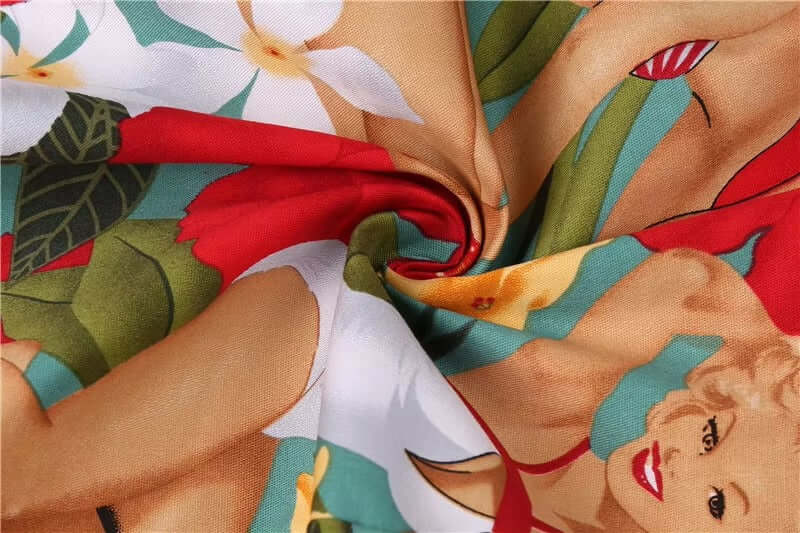 Close-up of vibrant Tropical Pinups Halter Top fabric featuring pinup girls and tropical flowers.