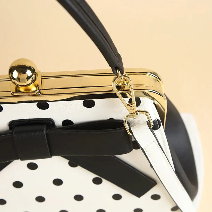 Close-up of Black Polka Dot Rockabilly Handbag featuring kiss-lock closure and stylish bow detail.