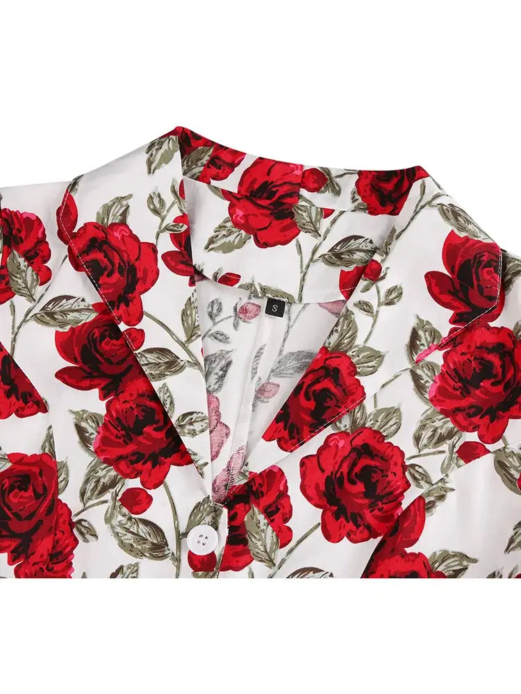 Close-up of the Rose Romance Vintage Swing Dress collar featuring bold red roses on a soft white background.