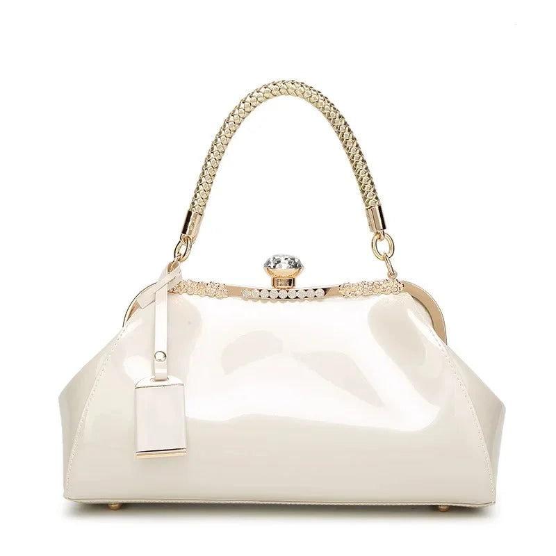 White patent women's handbag with a rhinestone lock and braided handle, perfect for stylish accessories.