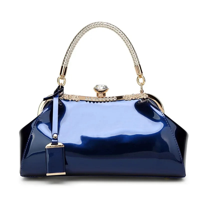 Blue patent women's handbag with a sleek design and rhinestone clip lock, perfect for stylish versatility.