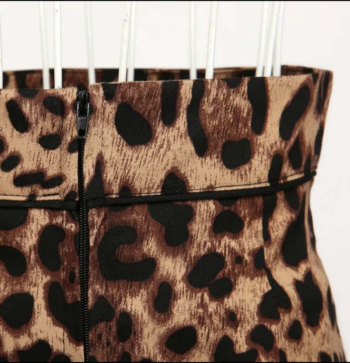 Close-up of the waistband and leopard print pattern on a stylish pencil skirt, showcasing its luxurious fabric and design details.