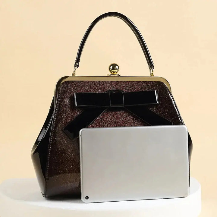 Chocolate Patent Rockabilly Handbag with a high-shine finish and bow, showcasing retro glamour and practical style.