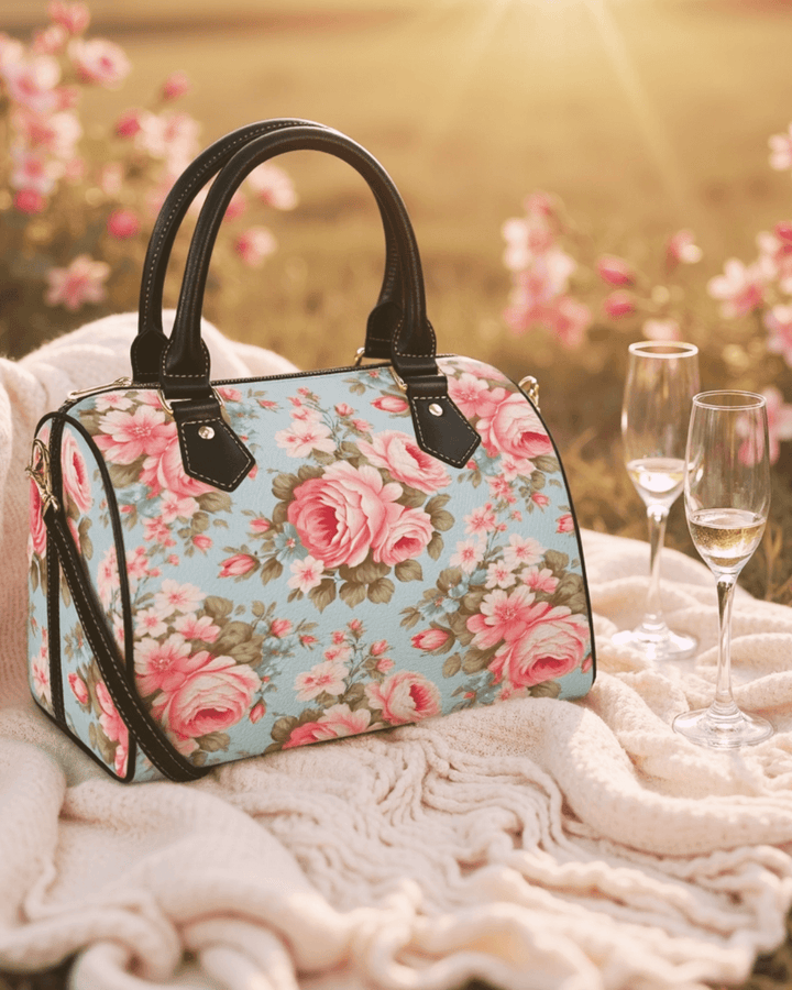 Vintage Roses handbag featuring floral design, set on a blanket with champagne glasses, capturing timeless elegance.