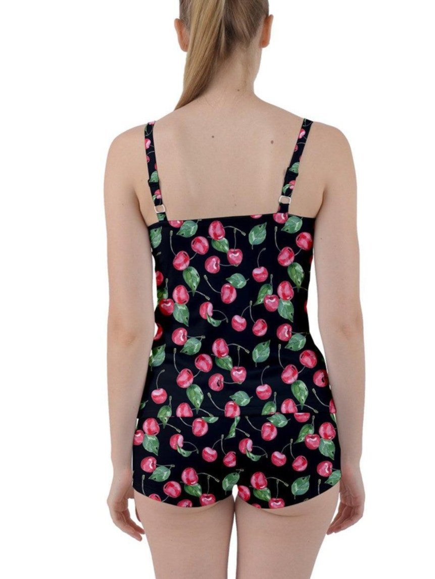 Back view of a woman in a cherry print tankini with adjustable straps, showcasing a fun summer swimsuit design.